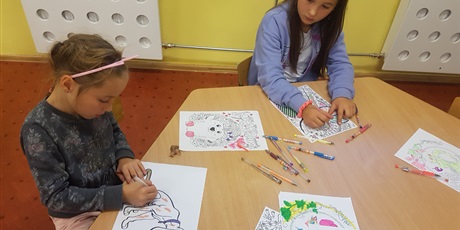Powiększ grafikę: Dziewczynki kolorują obrazki przedstawiające zwierzęta. 