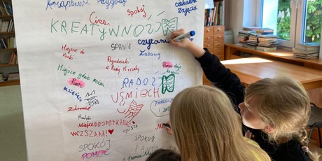 Powiększ grafikę: Dzieci piszą na tablicy.
