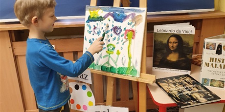 Powiększ grafikę: Chłopiec maluje obraz. 
