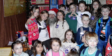 Powiększ grafikę: Dzieci stoją wokół św. Mikołaja.